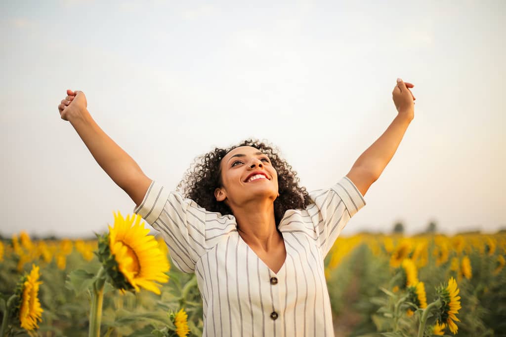 A person joyfully celebrating their addiction recovery, surrounded by supportive friends and family, symbolizing the success and happiness that holistic addiction recovery can bring.